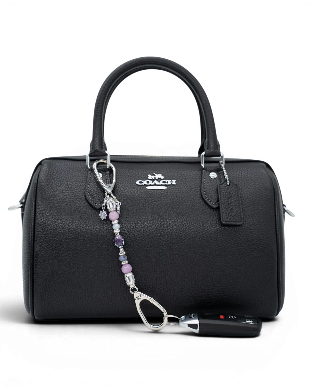 LD Keyfinder Petite Blooming Joy beaded accessory with lavender Lepidolite and purple Jade attached to a black handbag.