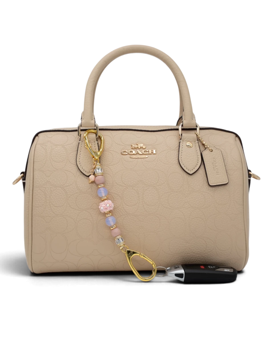 LD Keyfinder Petite Blush Sorbetto beaded accessory with pink opal, opalite, and gold ice cream charm on a beige bag