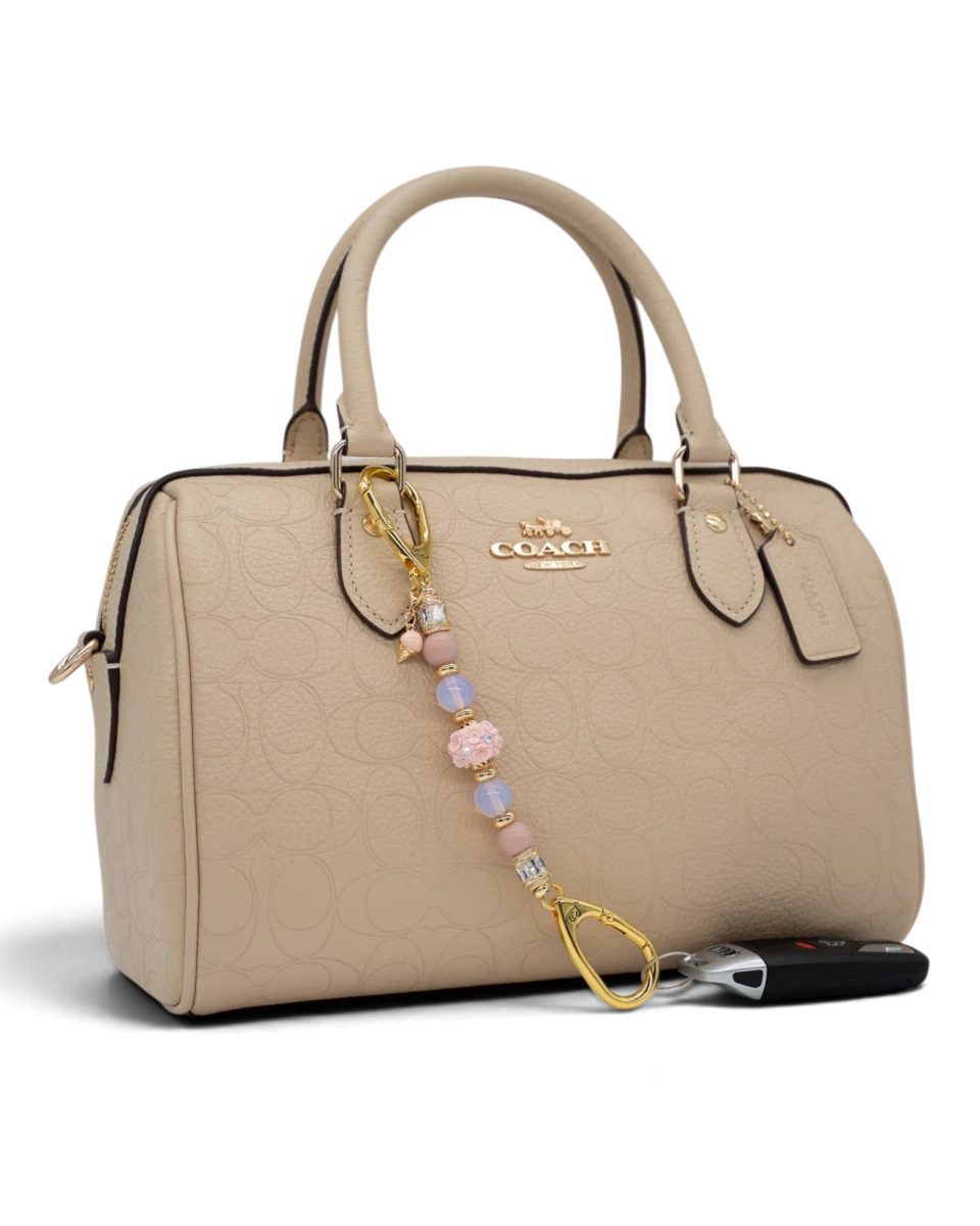 LD Keyfinder Petite Blush Sorbetto beaded keychain with pink opal, opalite, and floral charm on a beige handbag