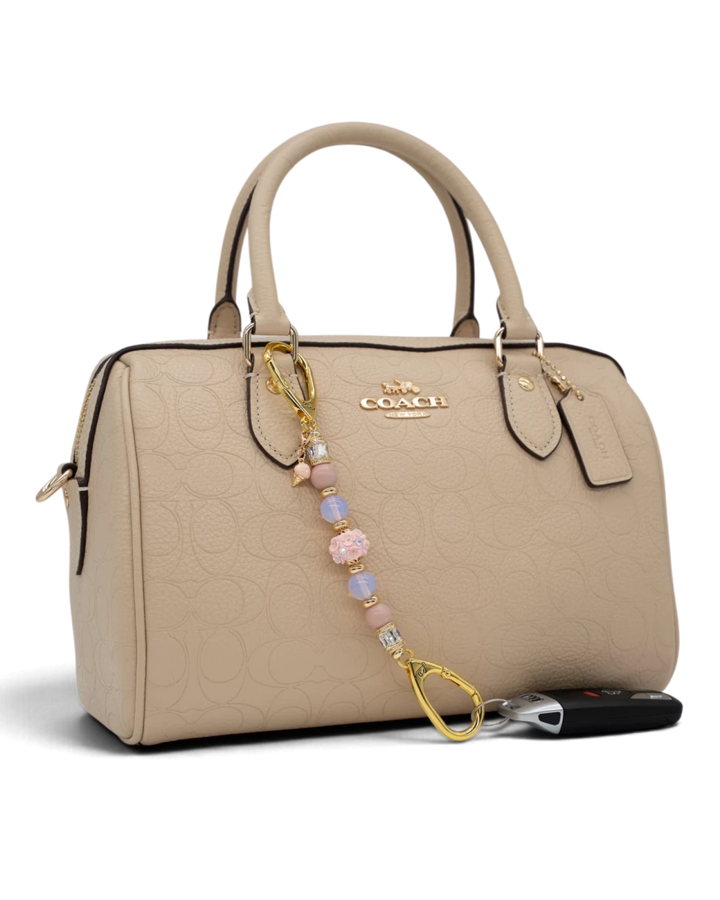 LD Keyfinder Petite Blush Sorbetto beaded keychain with pink opal, opalite, and floral charm on a beige handbag