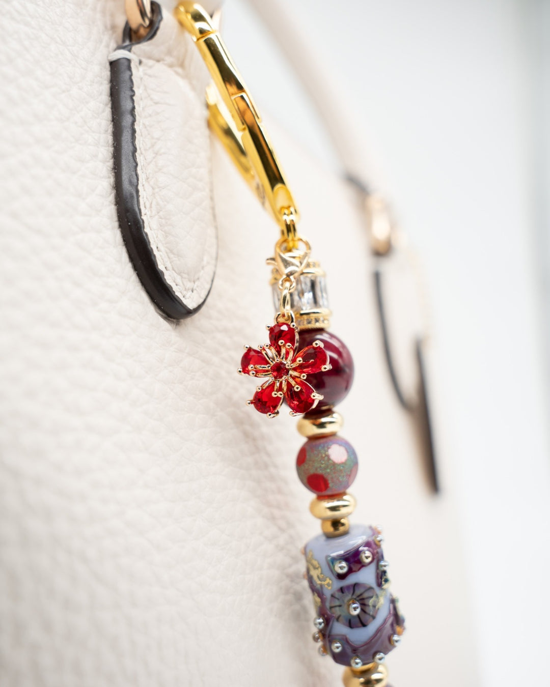 LD Keyfinder Petite Bordeaux Bloom featuring burgundy agate, artisan glass, gold-plated beads, and a red flower charm.