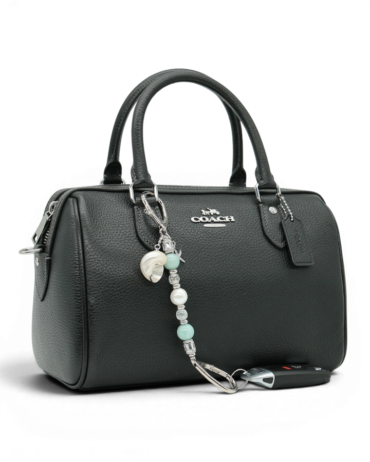LD Keyfinder Petite Caribbean Pearl beaded charm with shell and starfish accents attached to a black leather handbag.