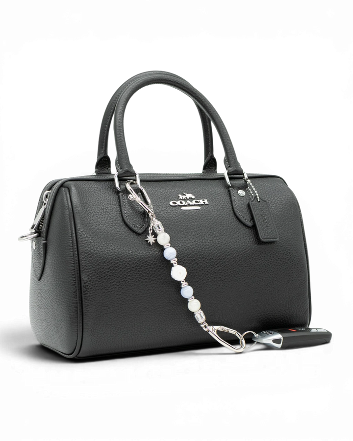 LD Keyfinder Petite Cloud Dancer beaded accessory with moonstone and blue lace agate attached to a black leather handbag