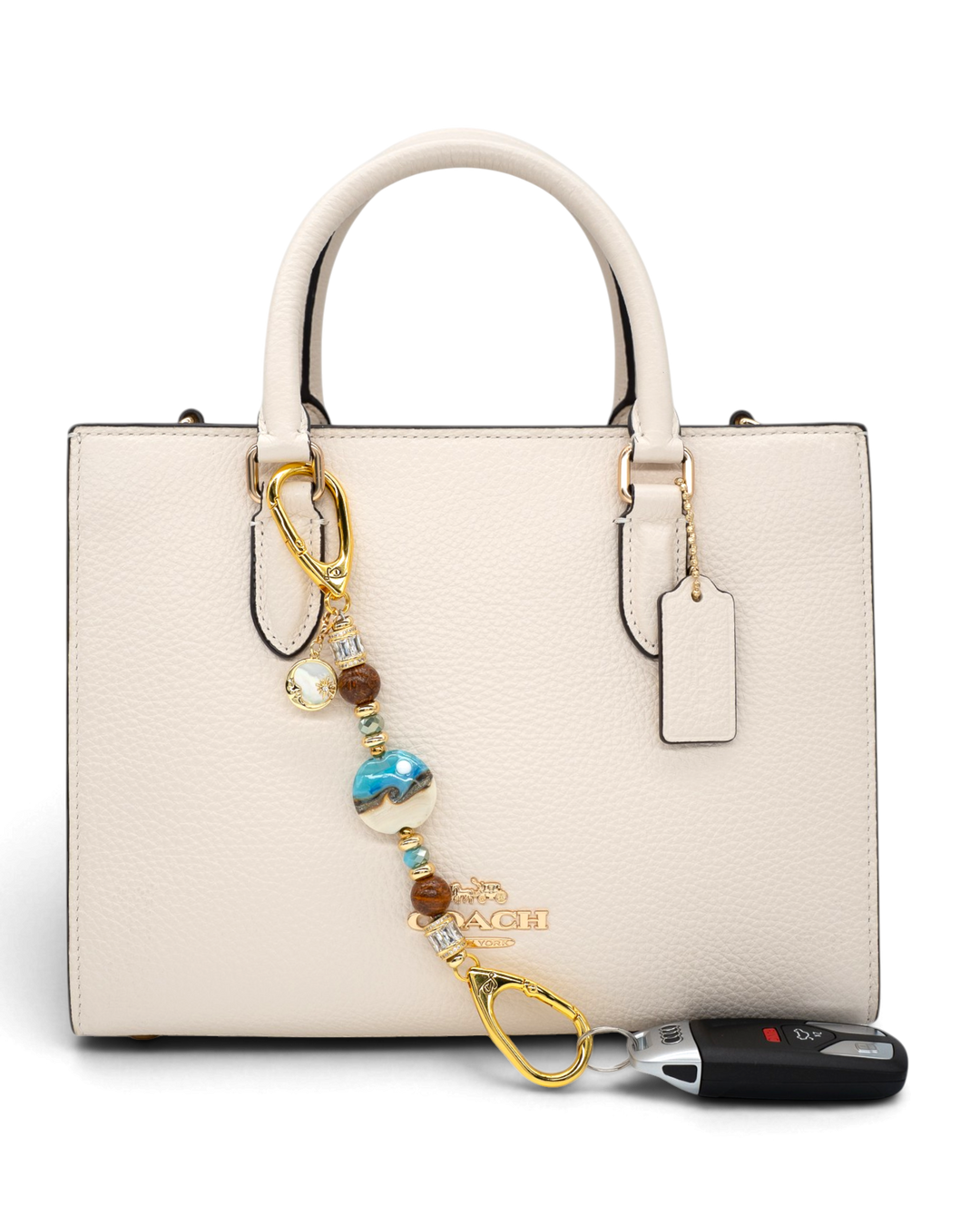 LD Keyfinder Petite Equinox Harmony beaded accessory with artisan glass, jasper, and gold moon charm attached to a handbag