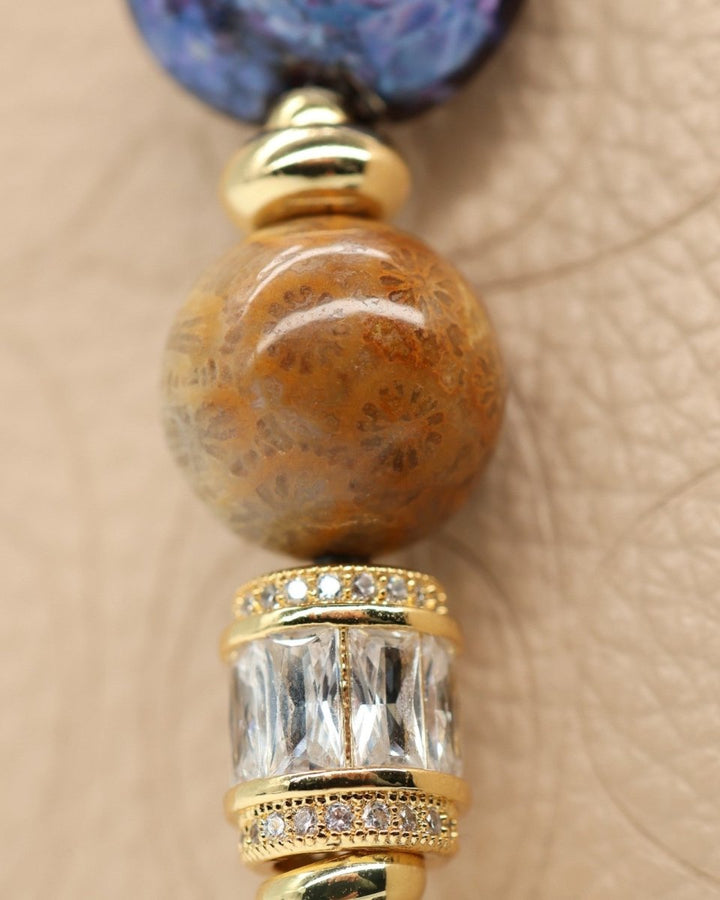 LD Keyfinder Petite Golden Nebula bracelet with fossil coral, artisan glass, baguette rhinestones, and gold-plated star charm.