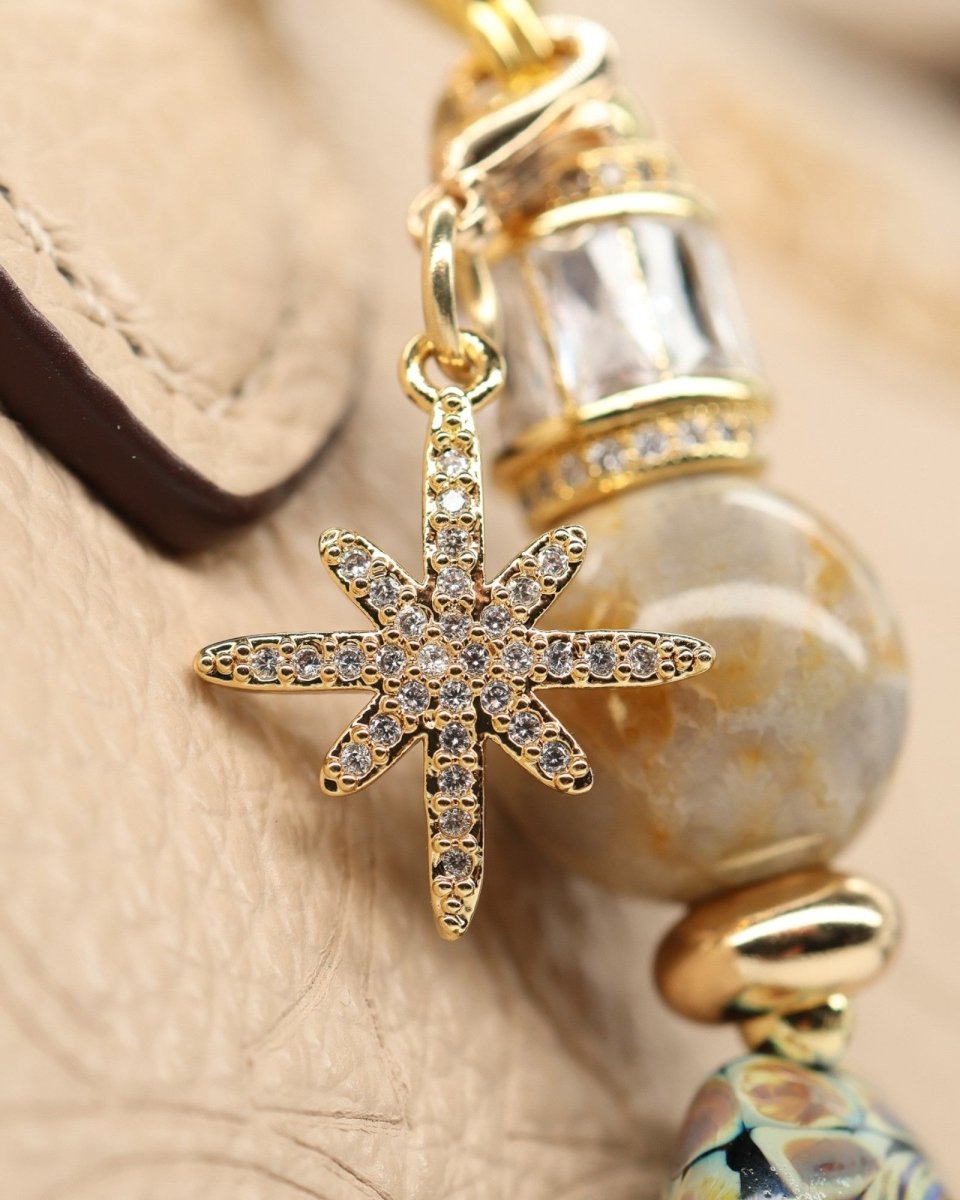 LD Keyfinder Petite Golden Nebula charm with a gold pavé star, fossil coral bead, artisan glass bead, and gold accents.