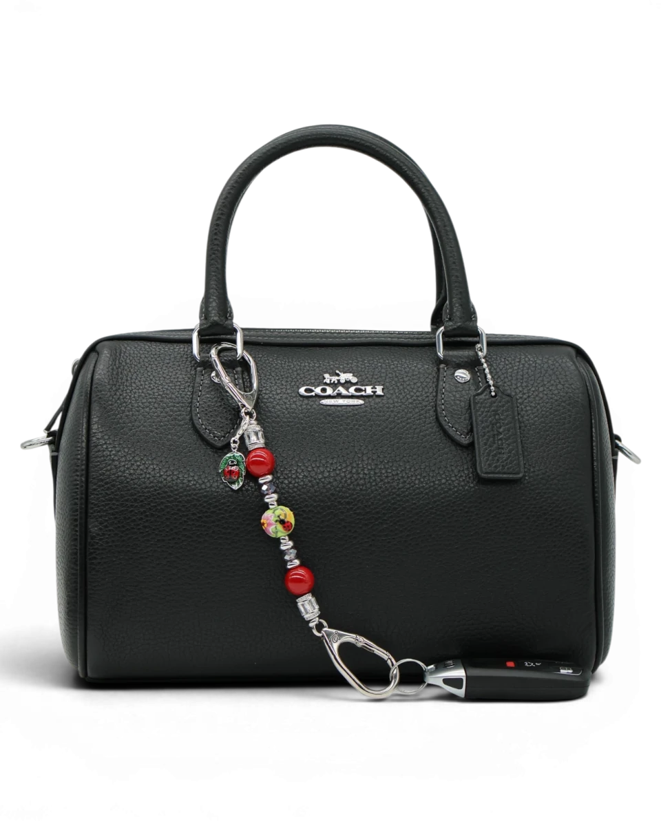 LD Keyfinder Petite Ladybug Love accessory with red shell pearls and artisan glass bead attached to a black handbag.