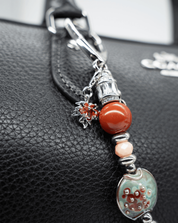 LD Keyfinder Petite Maple Majesty featuring red jasper, peach jade, artisan glass, and autumn-themed charms on a bag.