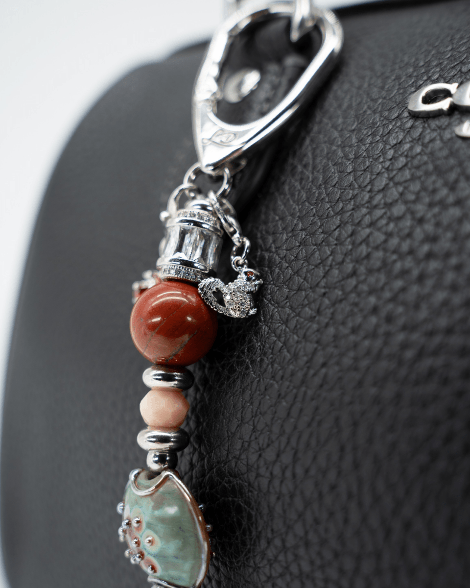 LD Keyfinder Petite Maple Majesty featuring red jasper, peach jade, artisan glass, and a squirrel charm on a handbag.