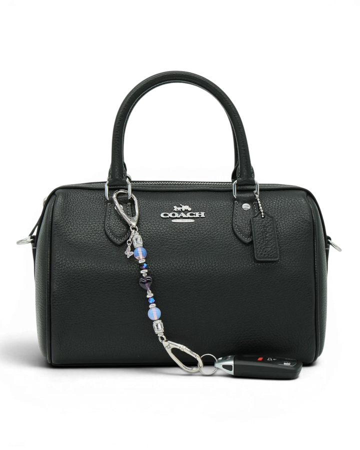 LD Keyfinder Petite Orchid Flutter accessory with pink opalite and purple glass beads attached to a black handbag.