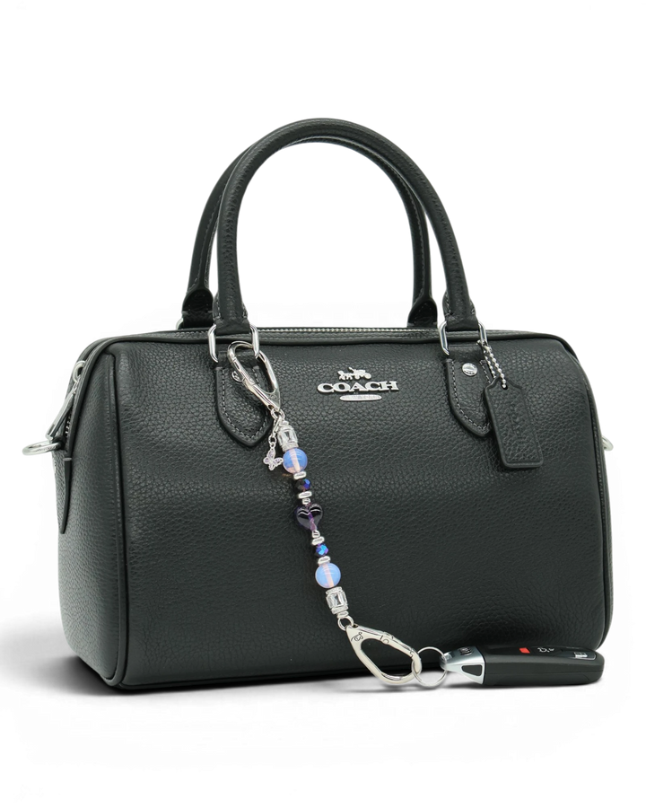 LD Keyfinder Petite Orchid Flutter accessory with pink opalite and purple glass beads attached to a black handbag.