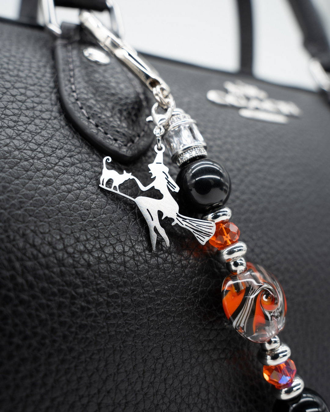 LD Keyfinder Petite Spellbound Halloween charm with black obsidian, orange glass, and a witch on a broomstick.