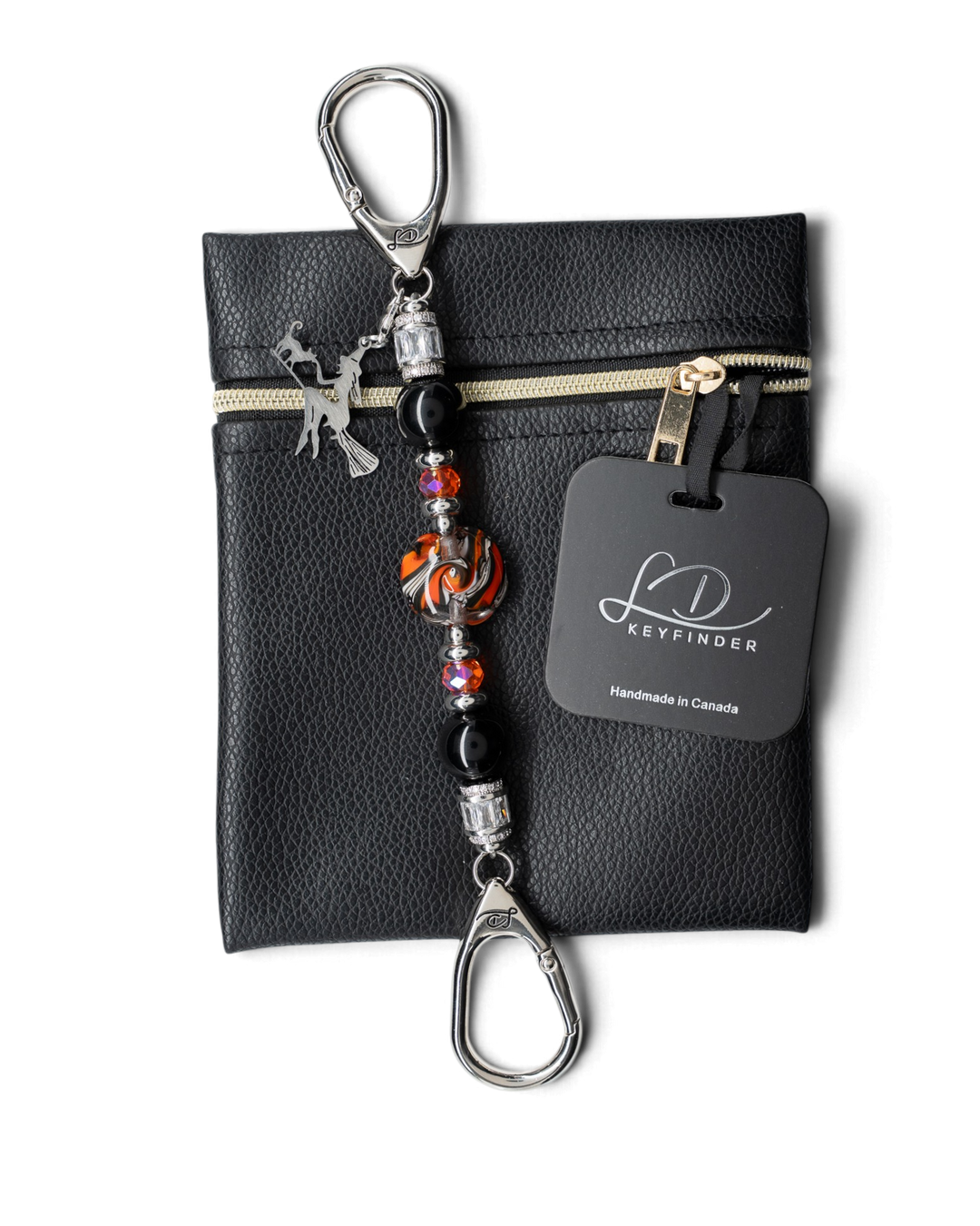 LD Keyfinder Petite Spellbound Halloween keychain with obsidian, orange glass, and a witch charm on a leather pouch.