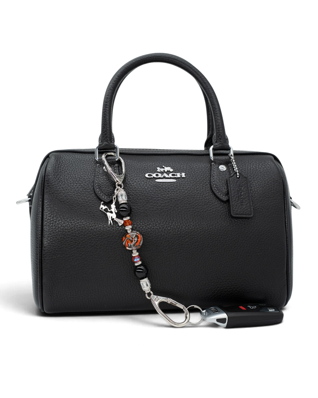 LD Keyfinder Petite Spellbound Halloween accessory with obsidian, orange glass, and a witch charm attached to a bag.