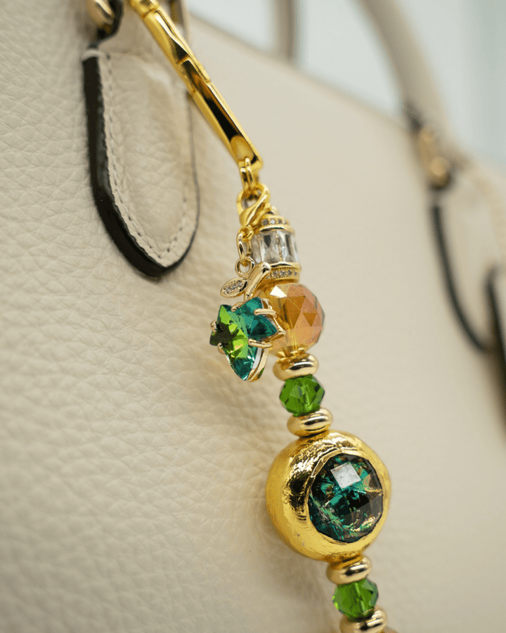 LD Keyfinder Petite Verdant Flame accessory with green and orange glass beads, gold-plated accents, and a leaf charm.