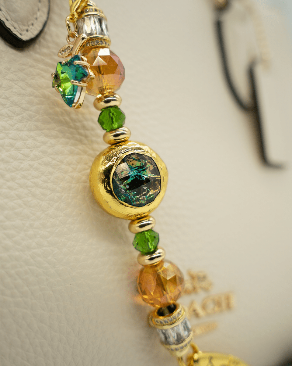 LD Keyfinder Petite Verdant Flame featuring orange and green glass beads, gold-plated accents, and a leaf charm.