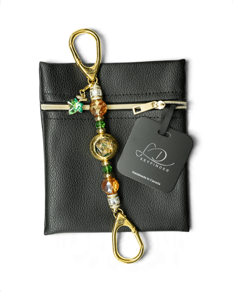 LD Keyfinder Petite Verdant Flame beaded accessory with orange and green glass beads, gold accents, and a leaf charm.