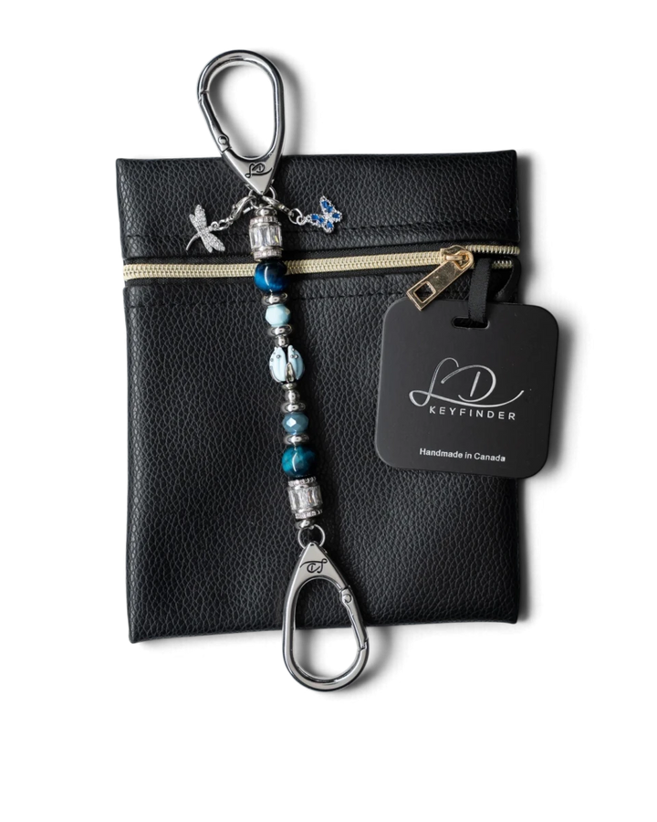 LD Keyfinder Petite Whispering Garden keychain with blue tiger eye, glass tulip, and dragonfly charm on a black pouch.