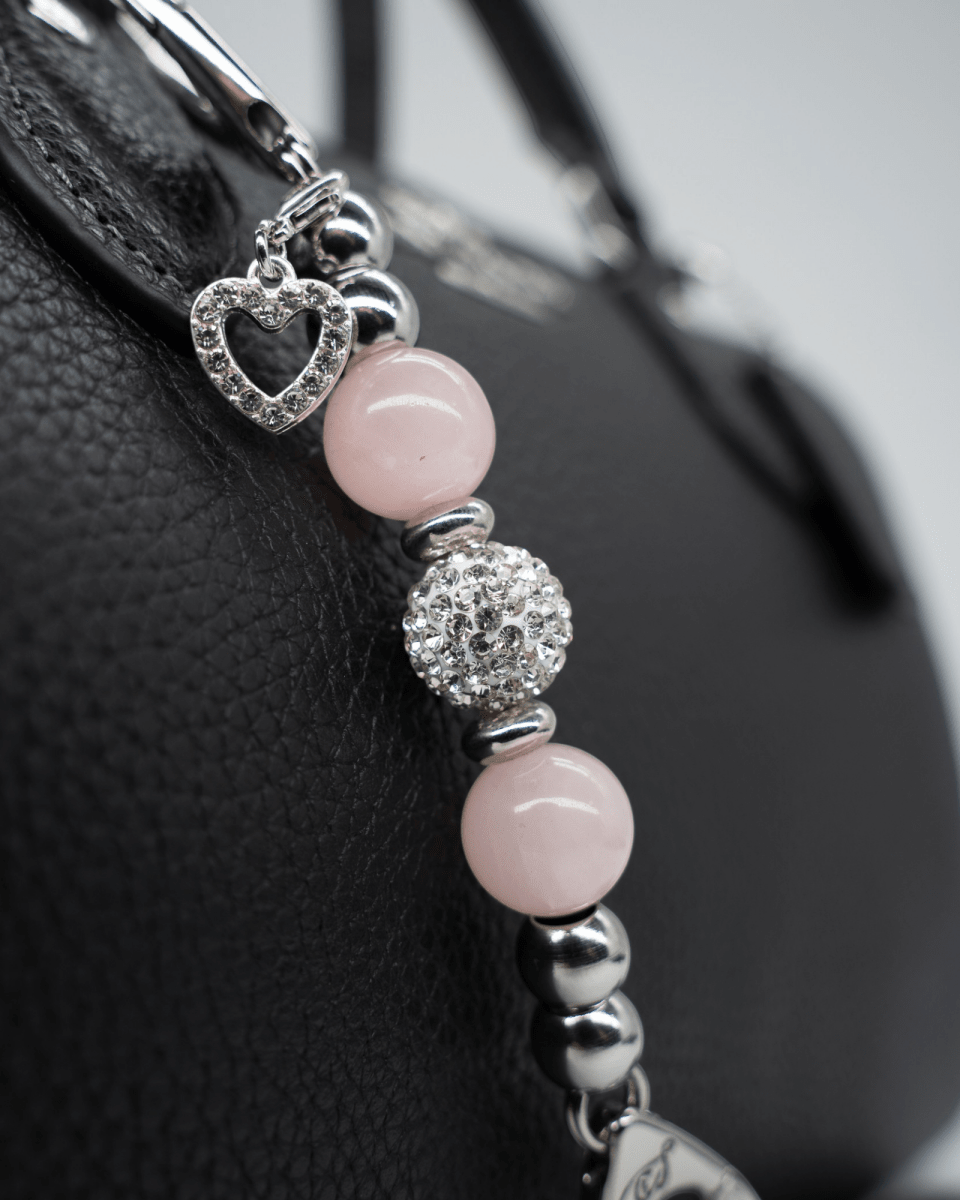 LD Keyfinder Princess Pink Mini keychain with rose quartz beads, rhinestone spacers, and a heart charm on a handbag.