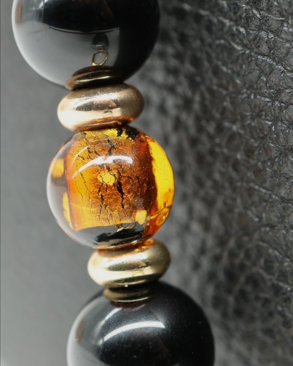 LD Keyfinder Queen Bee II necklace with black obsidian, amber foil glass beads, and gold-plated accents.