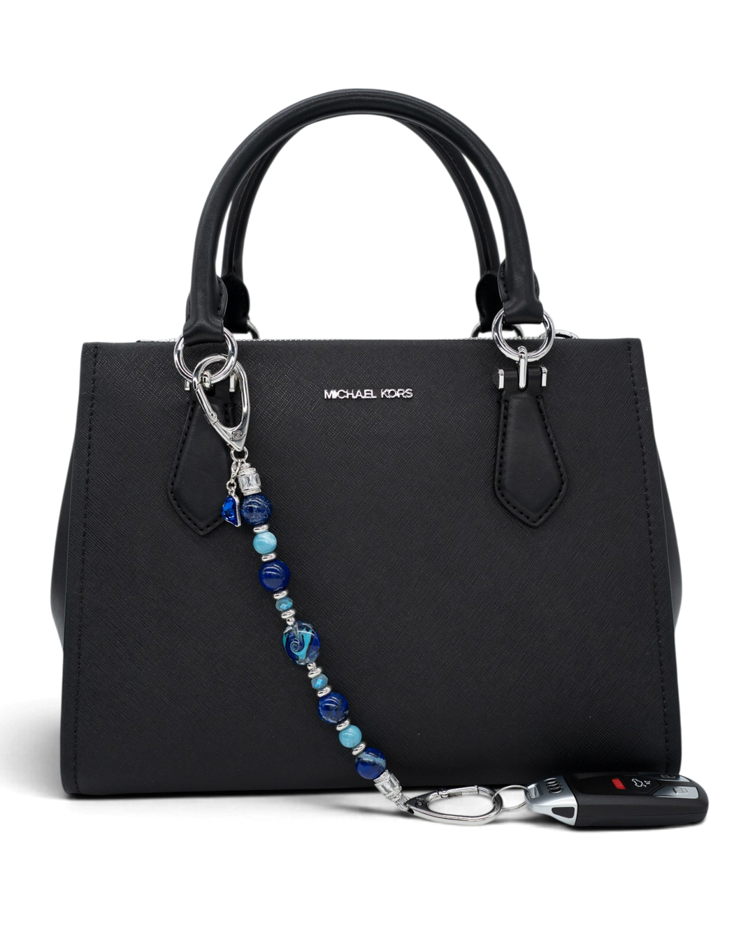 LD Keyfinder Sapphire Allure beaded accessory with blue gemstones and glass charms attached to a black handbag.