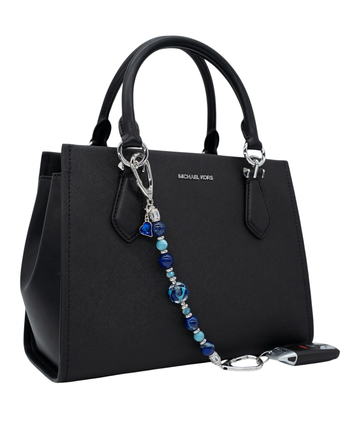 LD Keyfinder Sapphire Allure beaded accessory with blue jasper, larimar, and glass beads attached to a black handbag.
