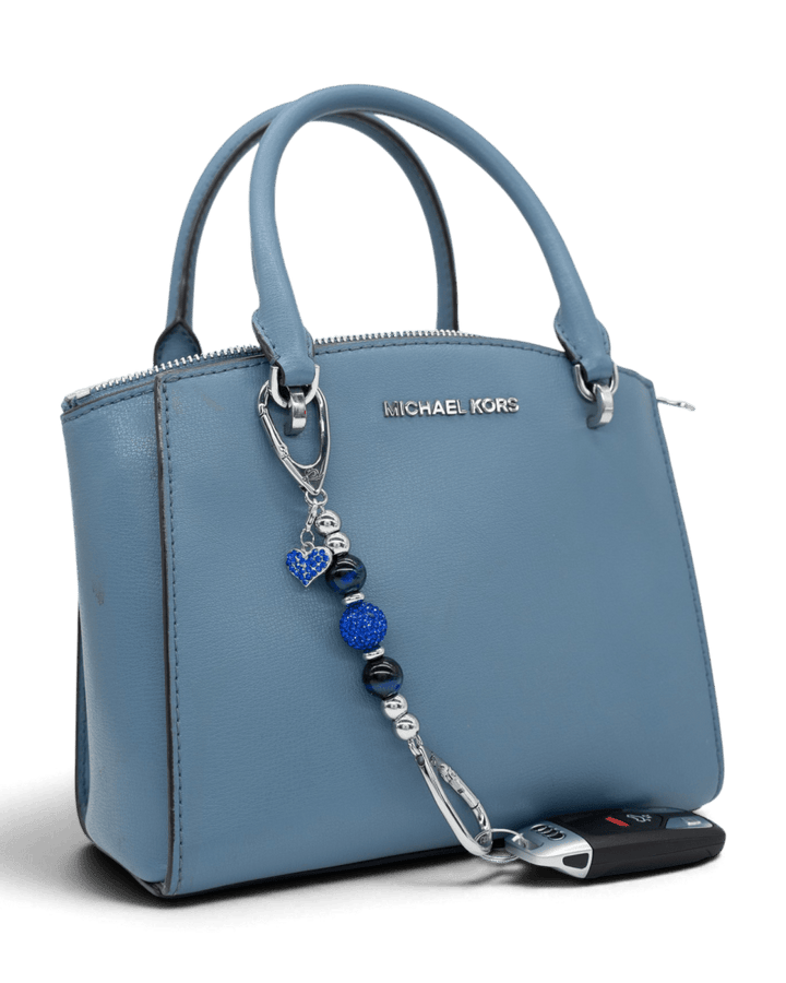 LD Keyfinder Sapphire Shimmer-Mini beaded charm with blue tiger eye and heart pendant attached to a blue handbag