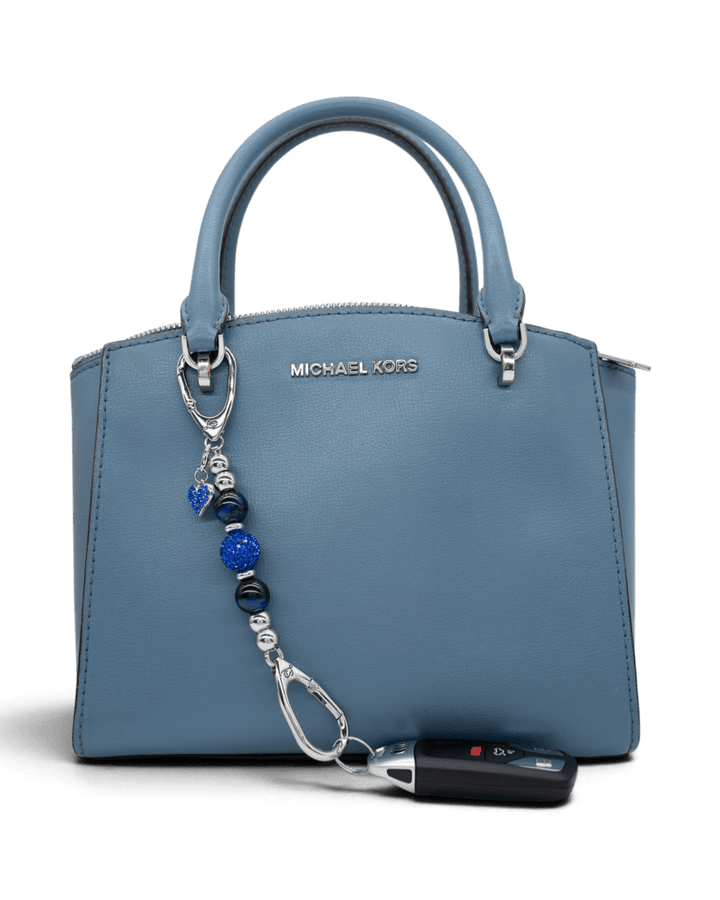 LD Keyfinder Sapphire Shimmer-Mini charm with blue tiger eye beads and heart charm attached to a blue handbag