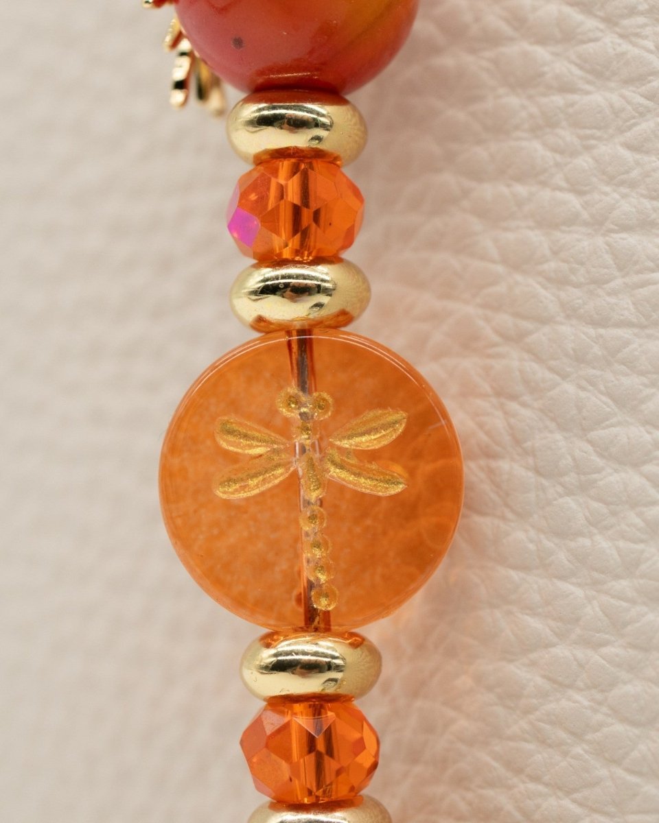 Electroplated coral glass center bead with metal-enlaced hand-painted dragonfly