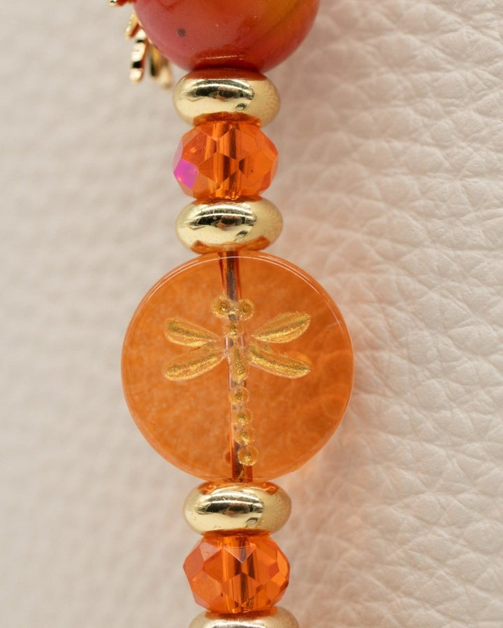Electroplated coral glass center bead with metal-enlaced hand-painted dragonfly
