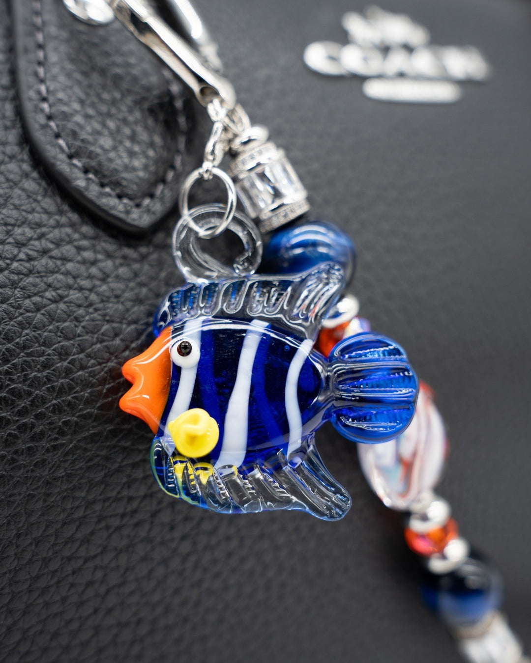 LD Keyfinder Petite Tropical Tango featuring a handcrafted blue and orange glass fish charm on a black leather bag