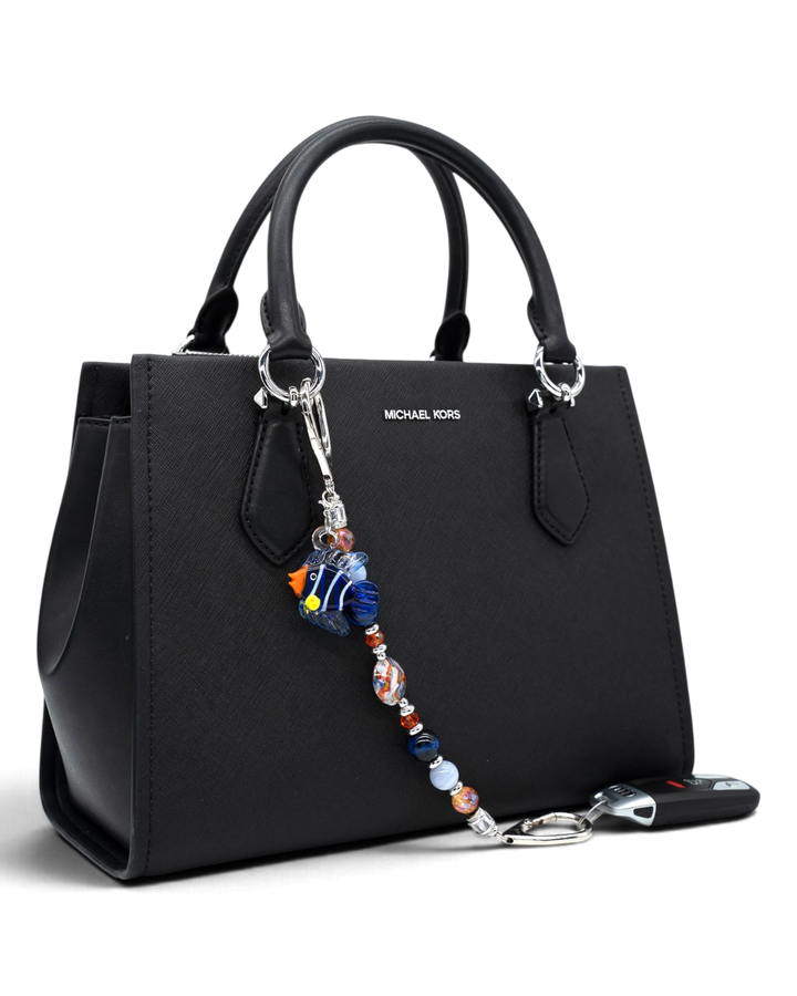 LD Keyfinder Tropical Tango beaded keychain with artisan glass fish charm attached to a black leather handbag