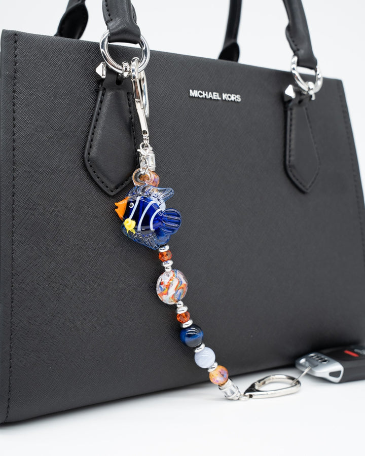 LD Keyfinder Tropical Tango key chain with a lampwork glass fish charm, gemstone beads, and orange glass accents on a bag.