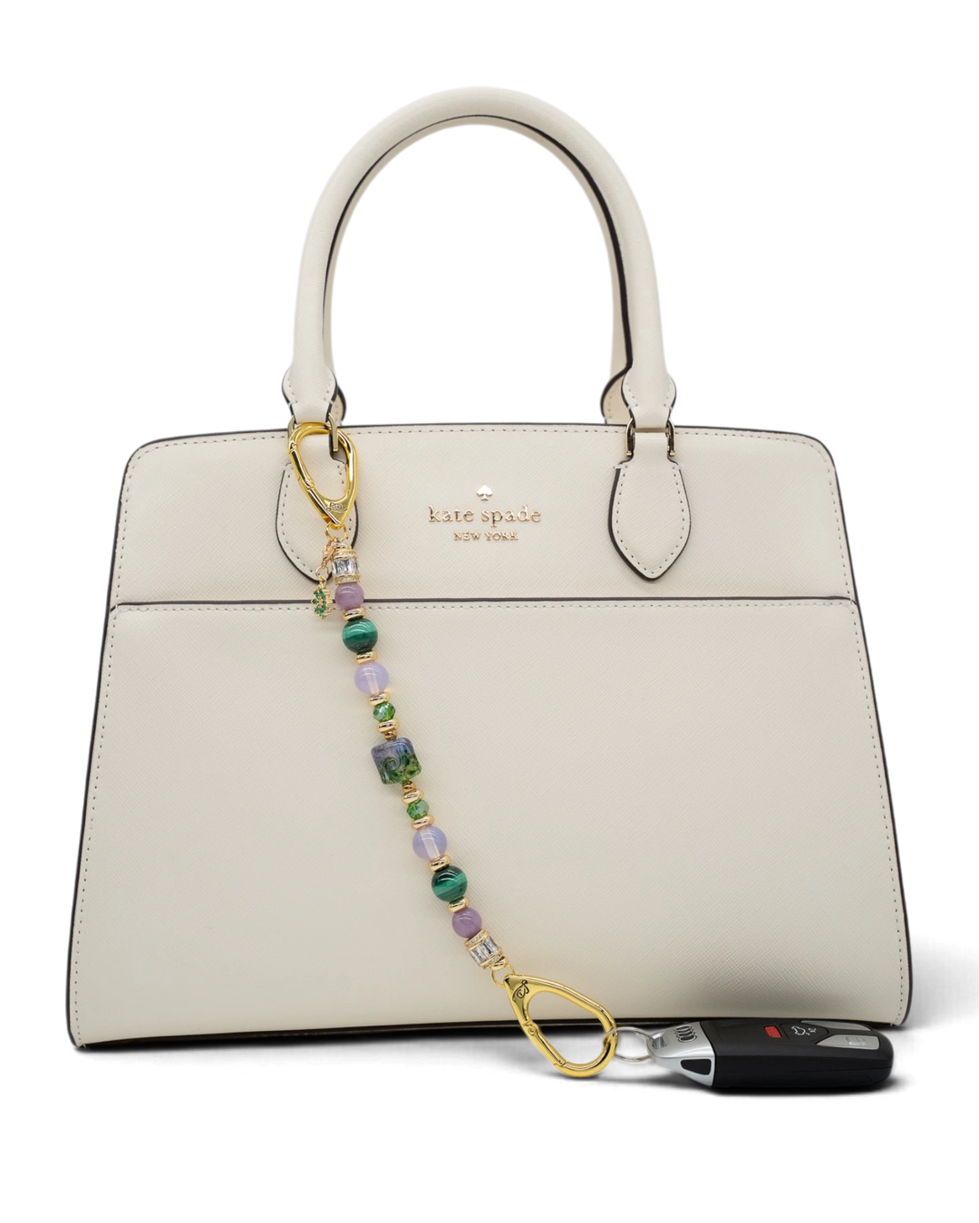 LD Keyfinder Verdant Bloom beaded accessory with lampwork glass, malachite, and opalite attached to a white handbag