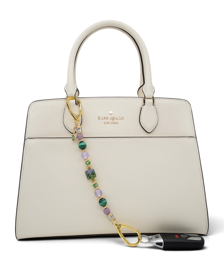 LD Keyfinder Verdant Bloom beaded accessory with lampwork glass, malachite, and opalite attached to a white handbag