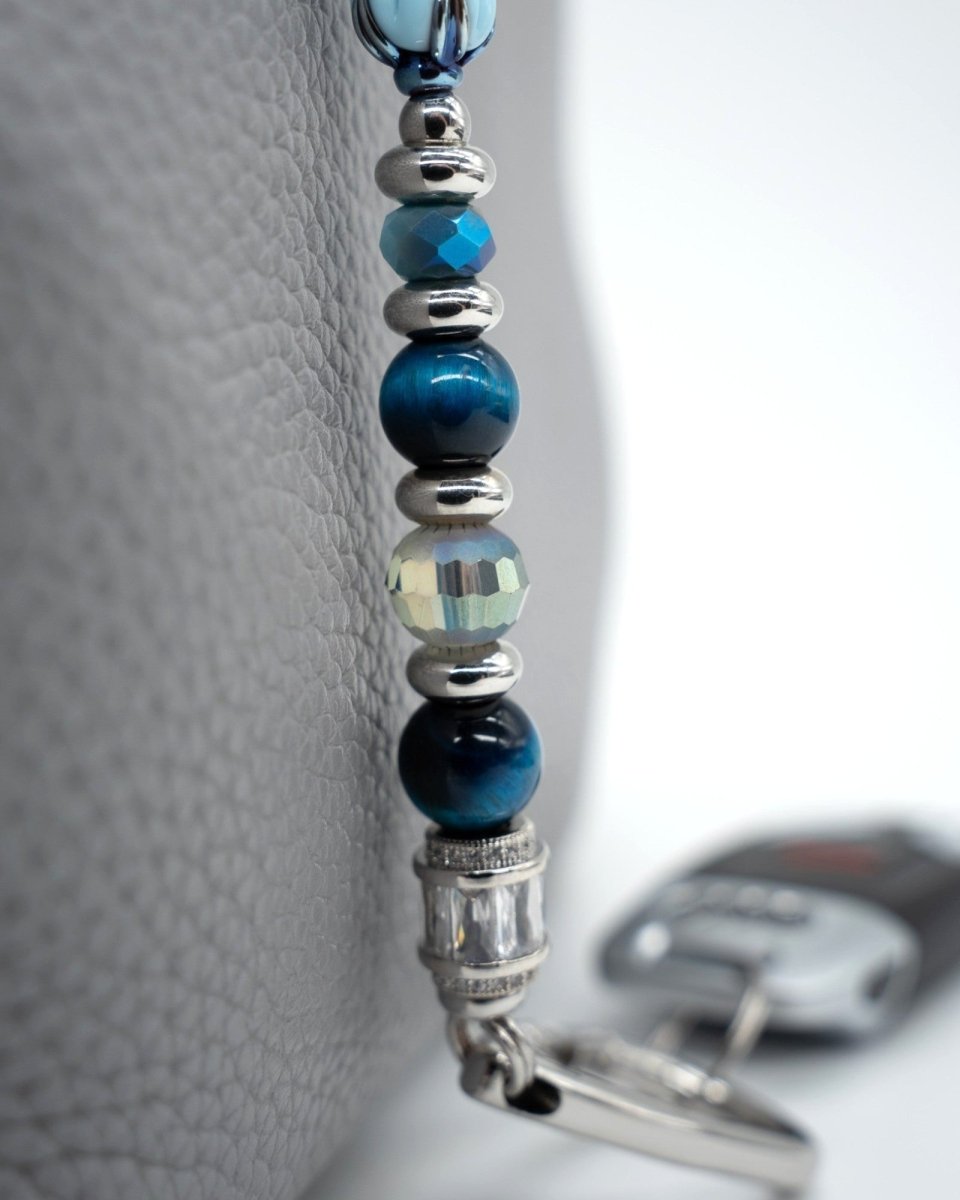 LD Keyfinder Whispering Garden accessory featuring blue tiger eye, faceted glass beads, and platinum-plated accents.