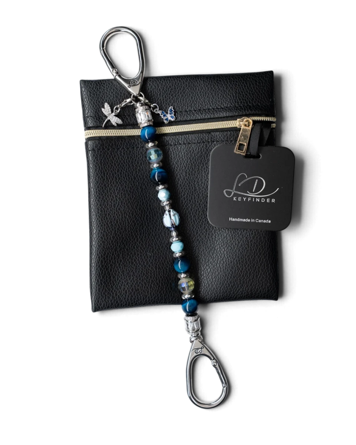 LD Keyfinder Whispering Garden beaded keychain with blue tiger eye, glass tulip, and dragonfly charm on a leather pouch.