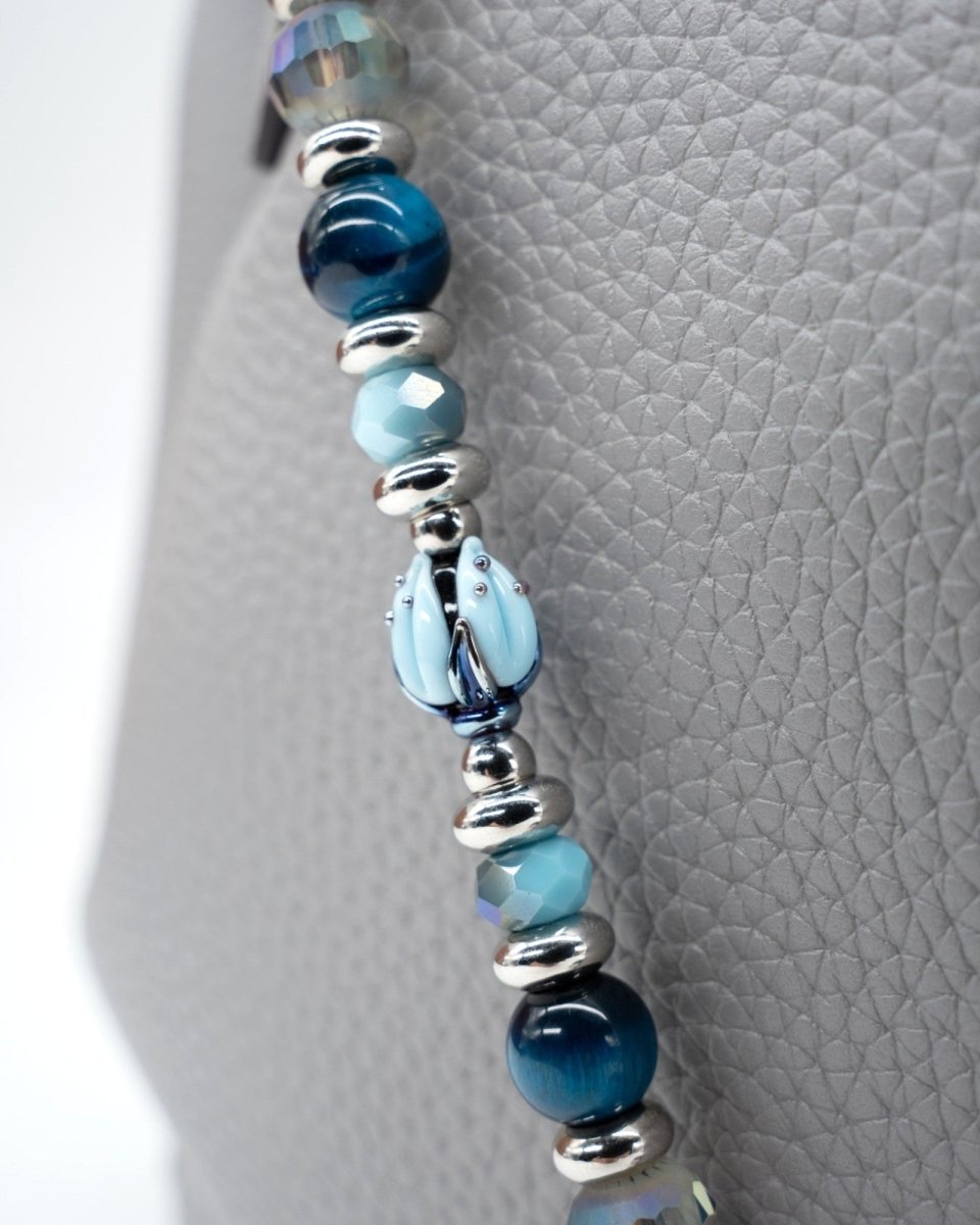 LD Keyfinder Whispering Garden beaded accessory featuring a handcrafted blue glass tulip, tiger eye, and crystal beads.