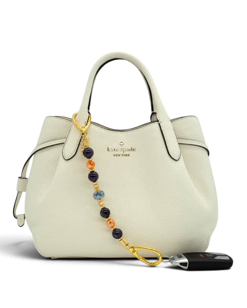 LD Keyfinder Whoo's There beaded accessory with amethyst and crystal beads on a white Kate Spade handbag